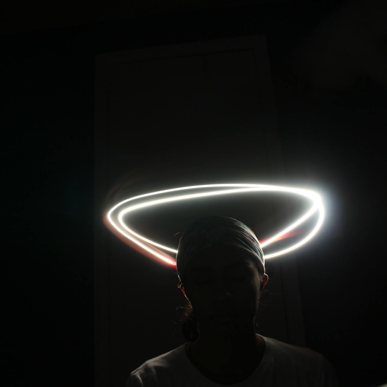 Photograph of a person standing in the dark with bright halo