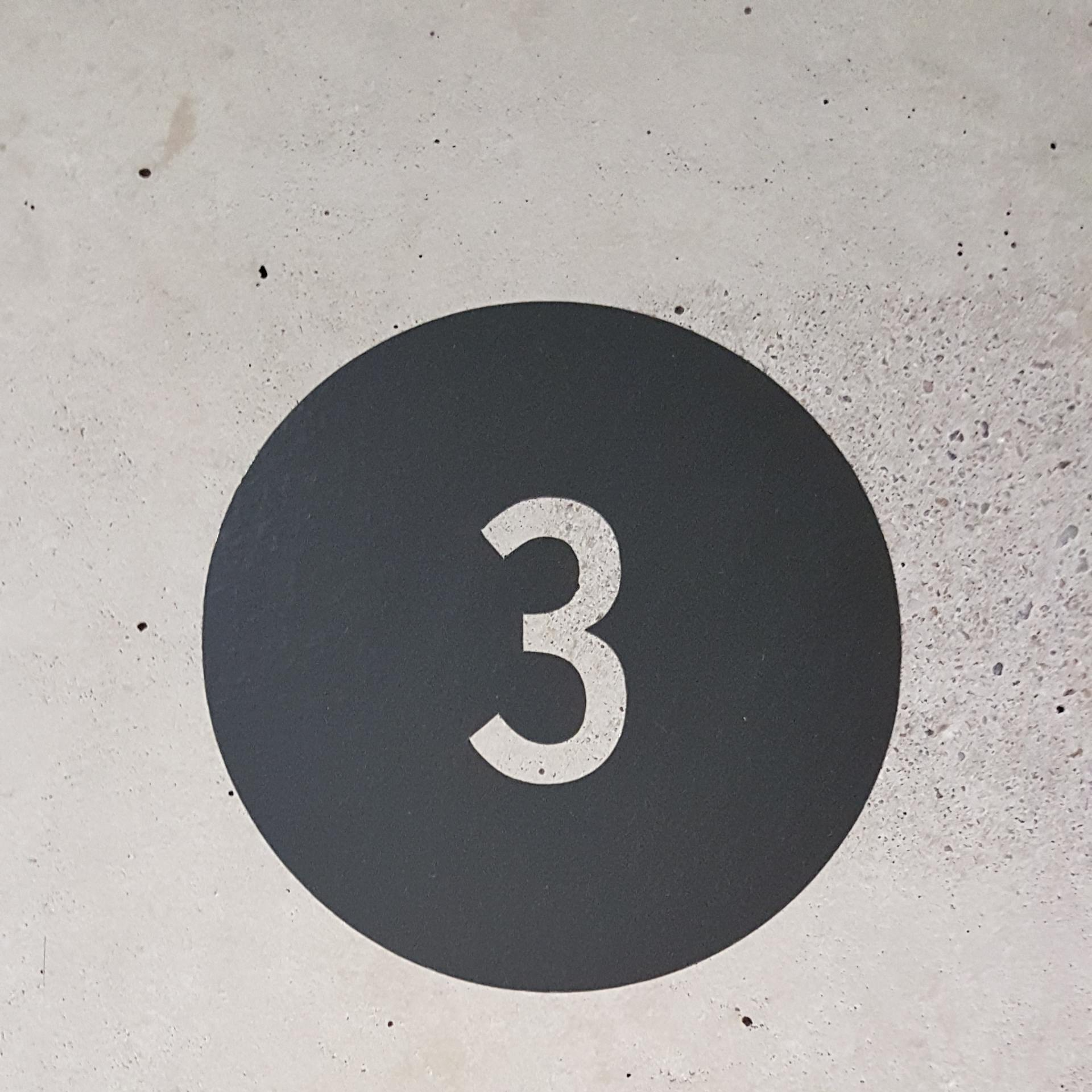 Photograph of black circle with white 3 in the centre