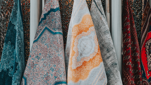 Colorful patterned fabrics hanging for display.