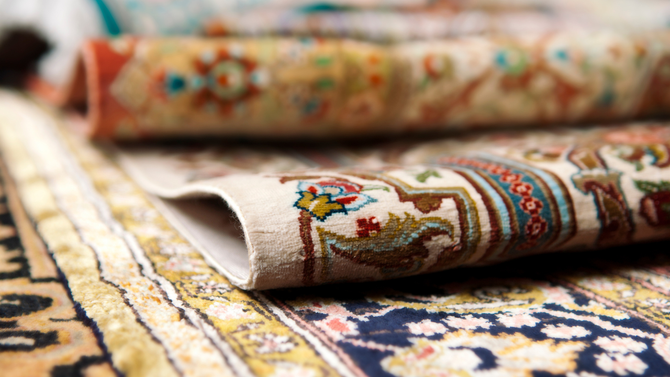 Rolled, colorful oriental rugs, showing patterns and textures.