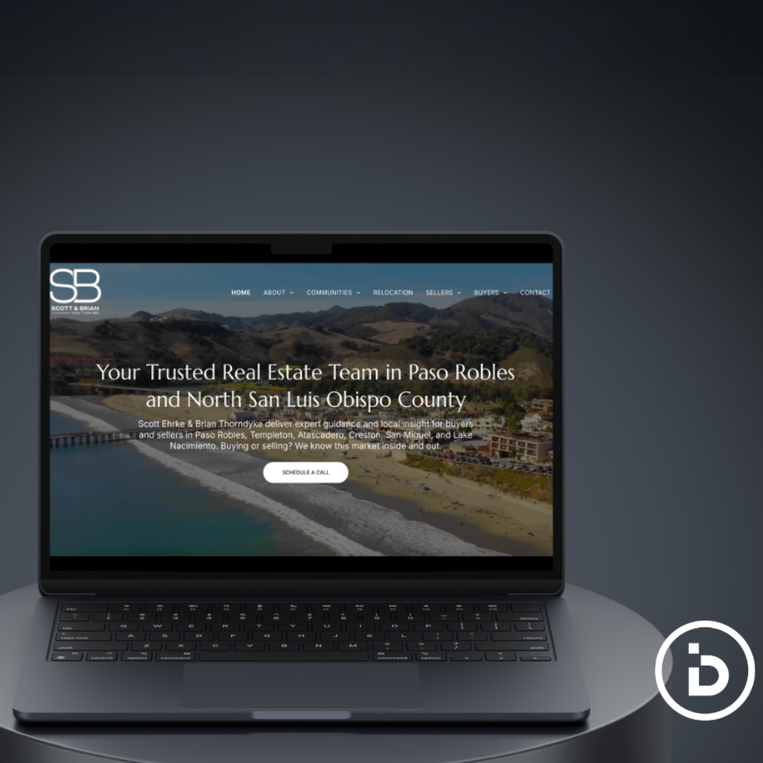 Laptop displaying a custom real estate website design for Scott & Brian, showcasing a coastal background.