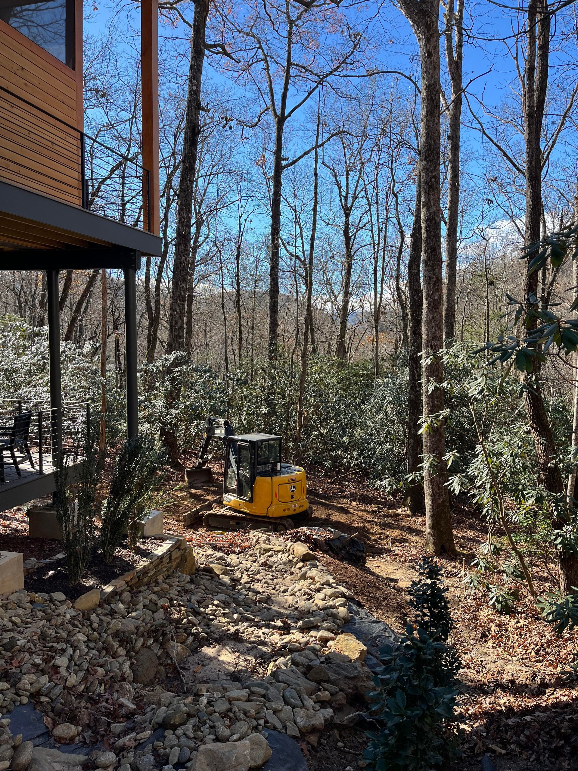 Rain is falling on a brick driveway in front of a house.