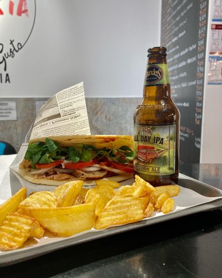 Un panino e una bottiglia di birra su un vassoio