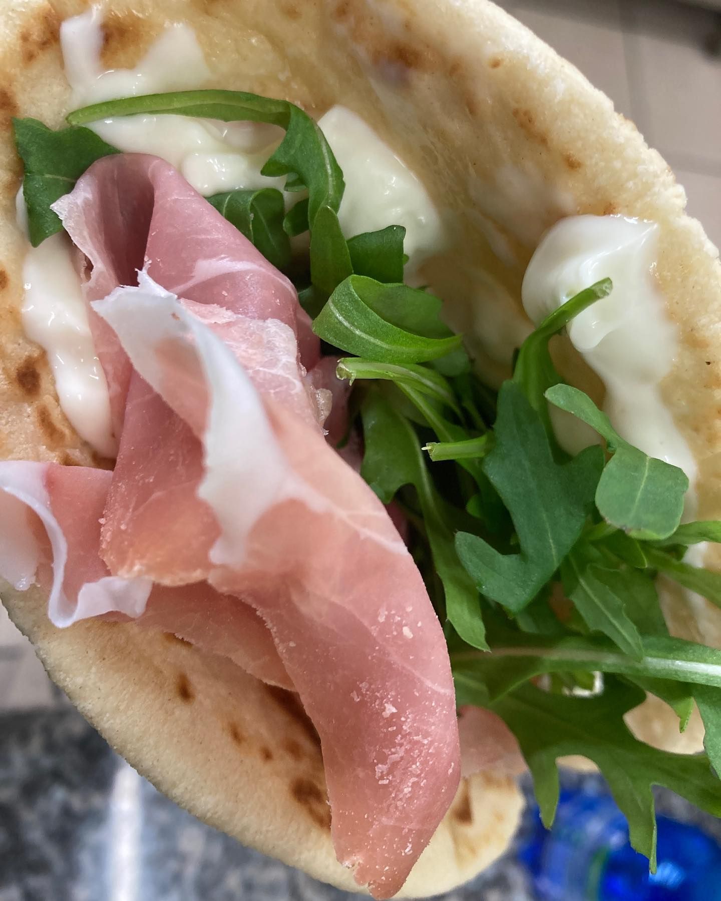 Un primo piano di un taco con prosciutto, formaggio e verdure