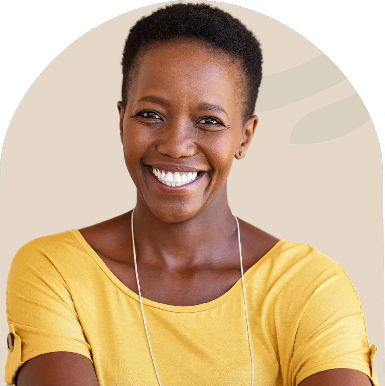 A woman in a yellow shirt is smiling with her arms crossed.