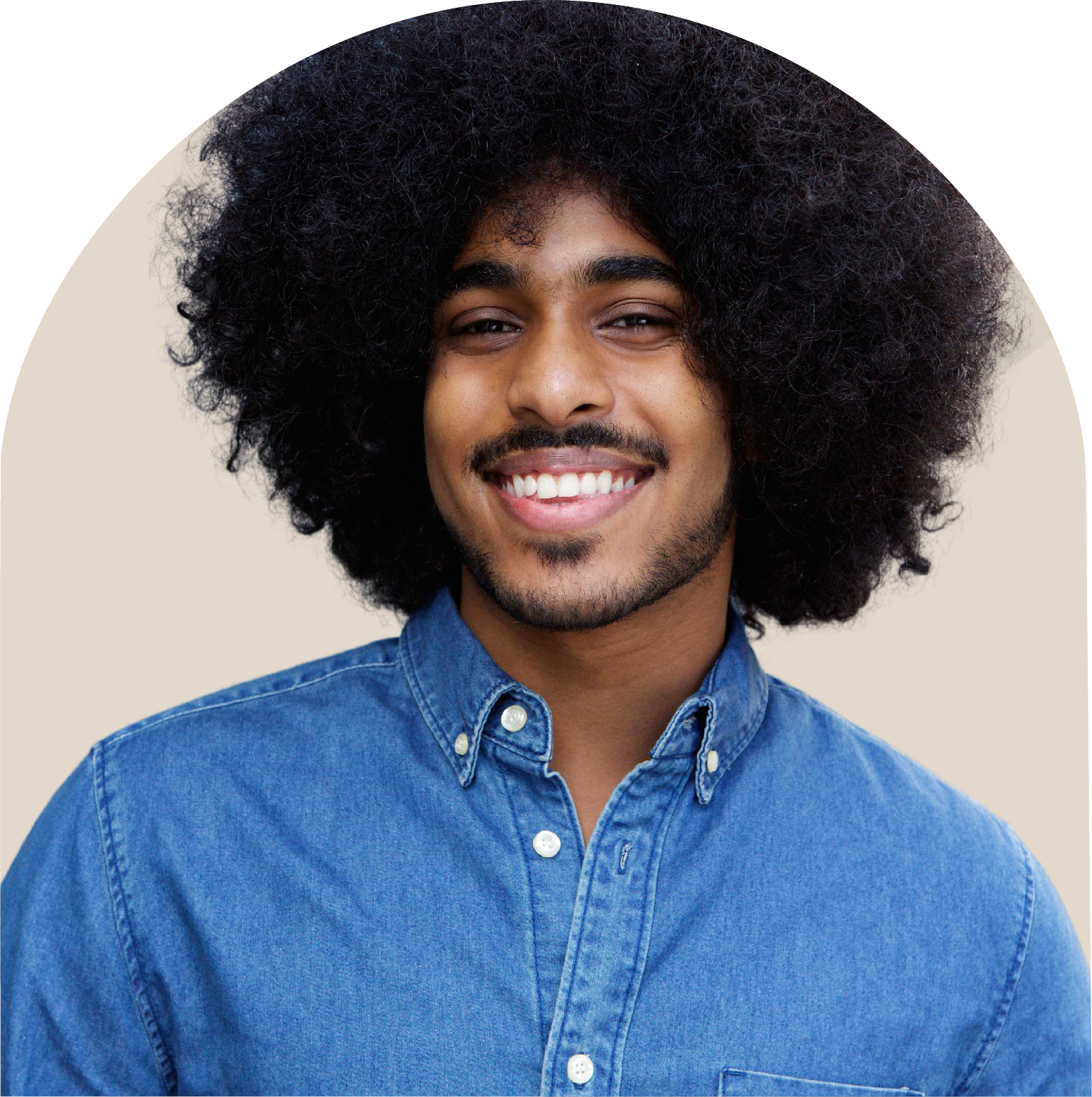 A man with an afro and a beard is wearing a blue shirt and smiling.