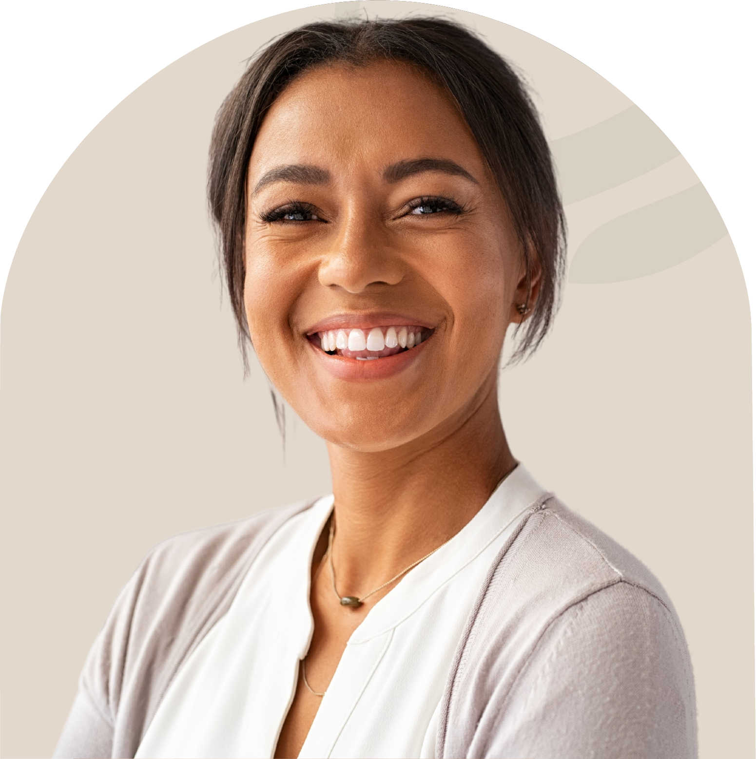 A woman in a white shirt and gray sweater is smiling for the camera.