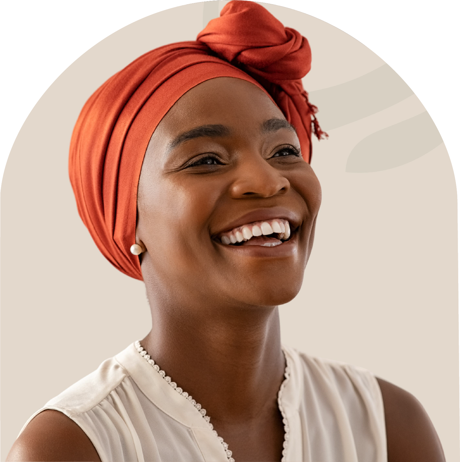 A woman wearing an orange turban is smiling and wearing a white shirt.