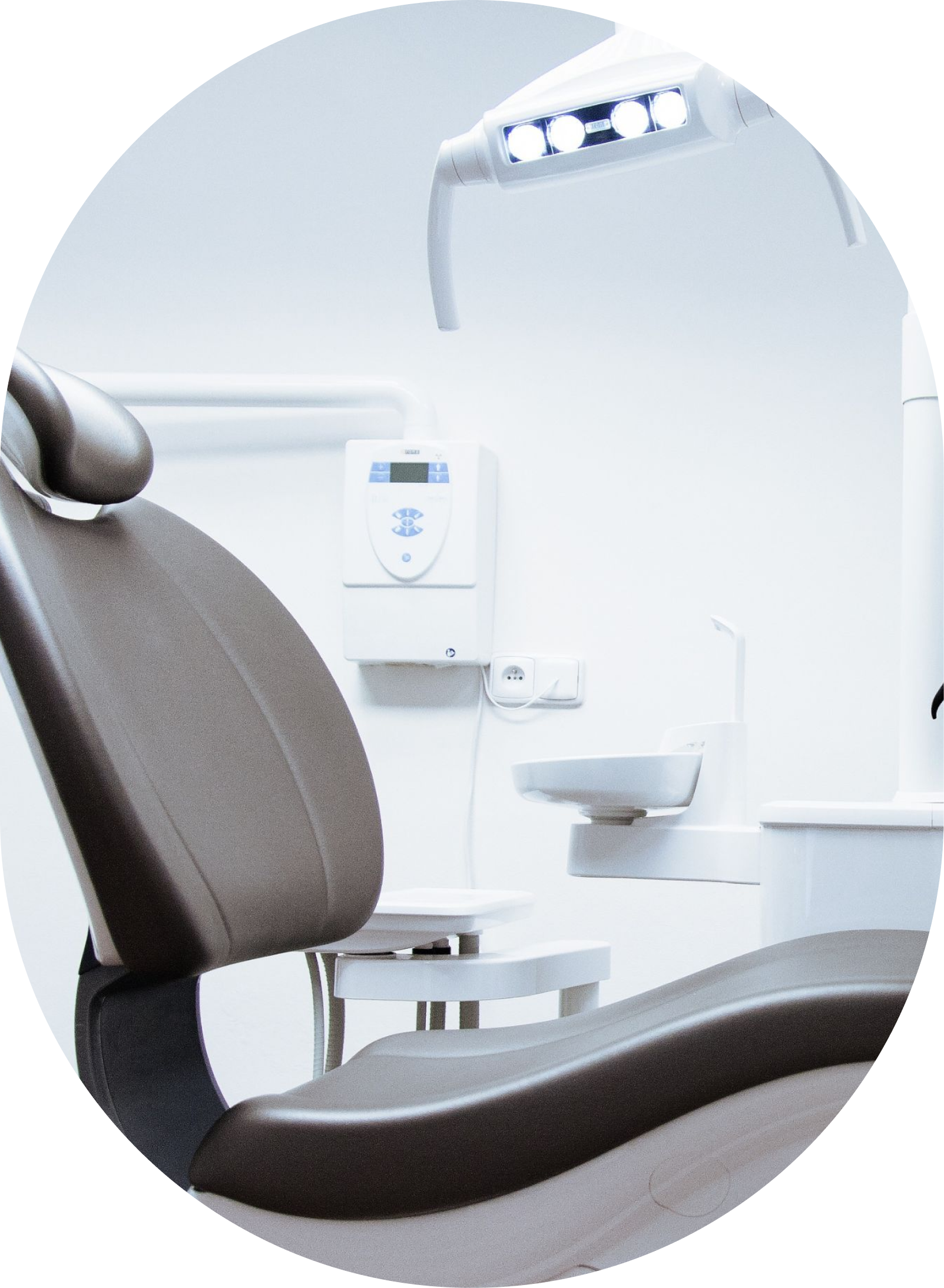 A dental chair in a dental office with a sink in the background