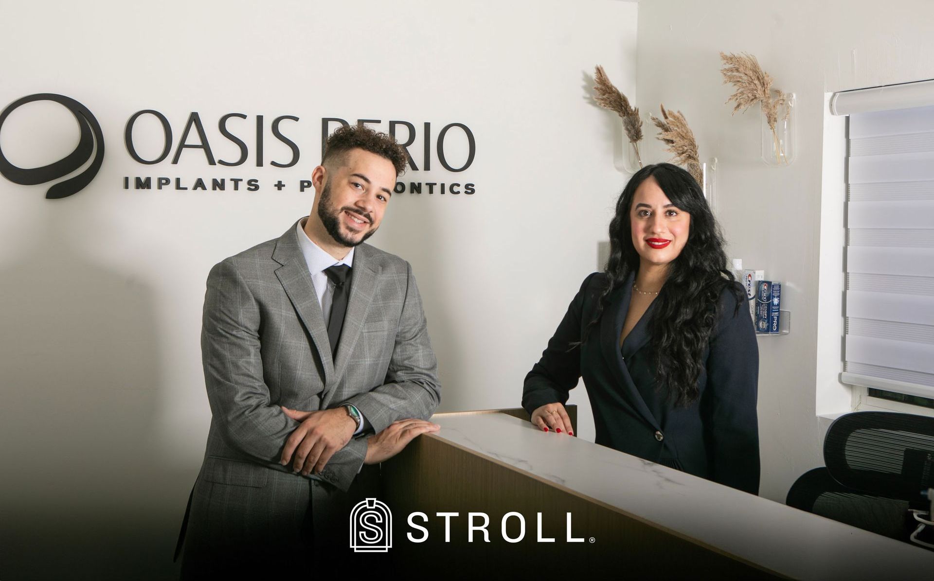 A man and a woman are standing at a counter in a dental office.