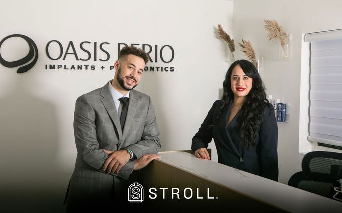 A man and a woman are standing at a counter in a dental office.