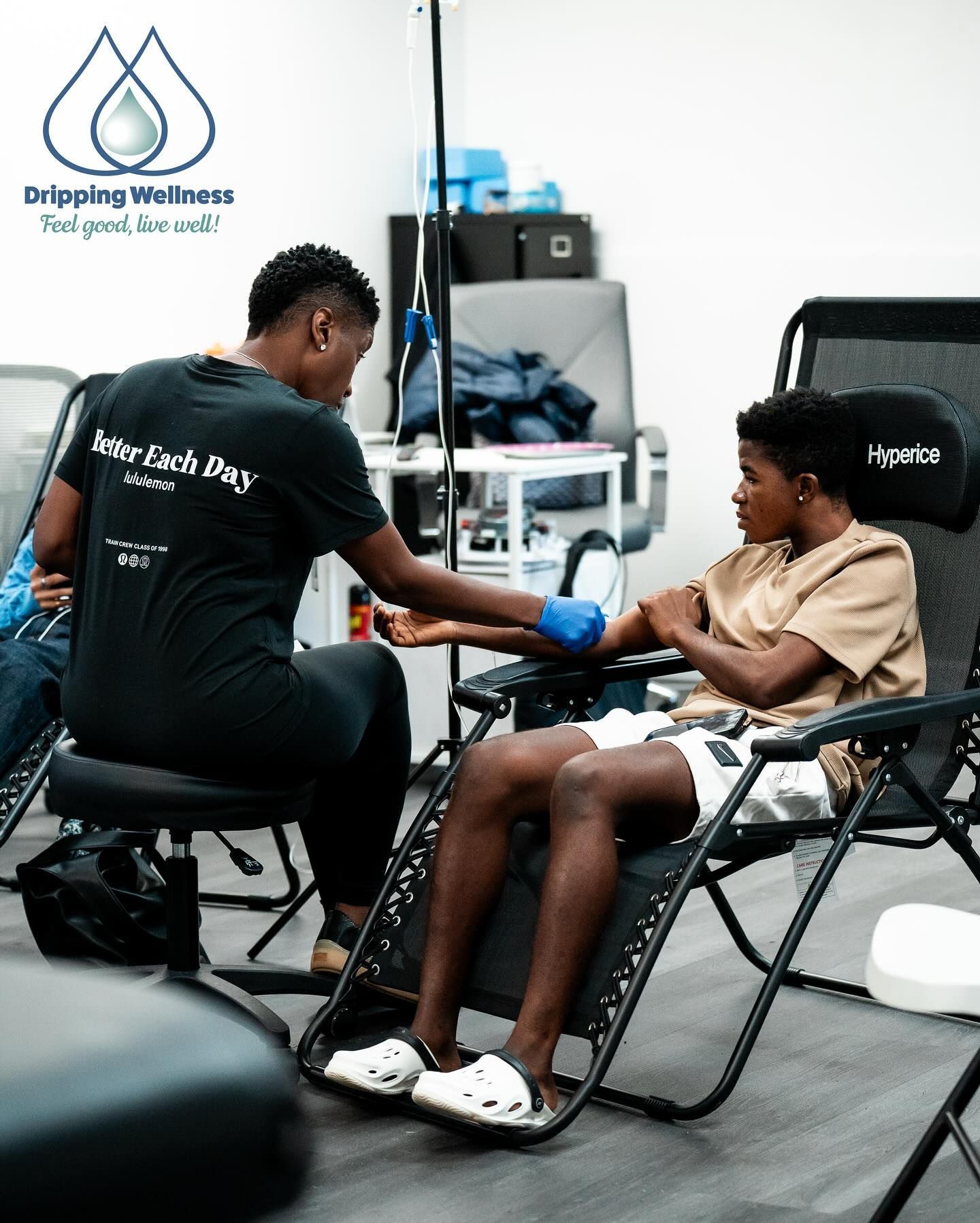 CEO Faith Stample, LPN prepares to draw blood from another's arm in a medical setting.