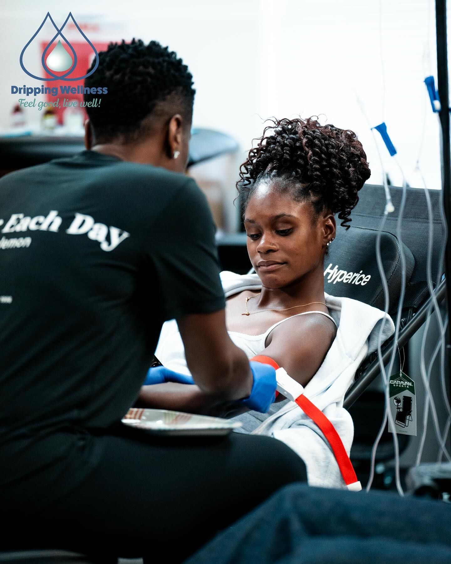 Person receiving IV drip in medical setting. 