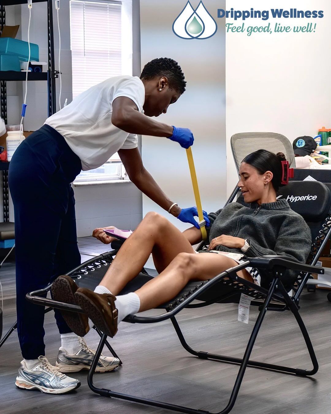 CEO Faith Stample, LPN prepares intravenous drip on another person seated in a recliner.