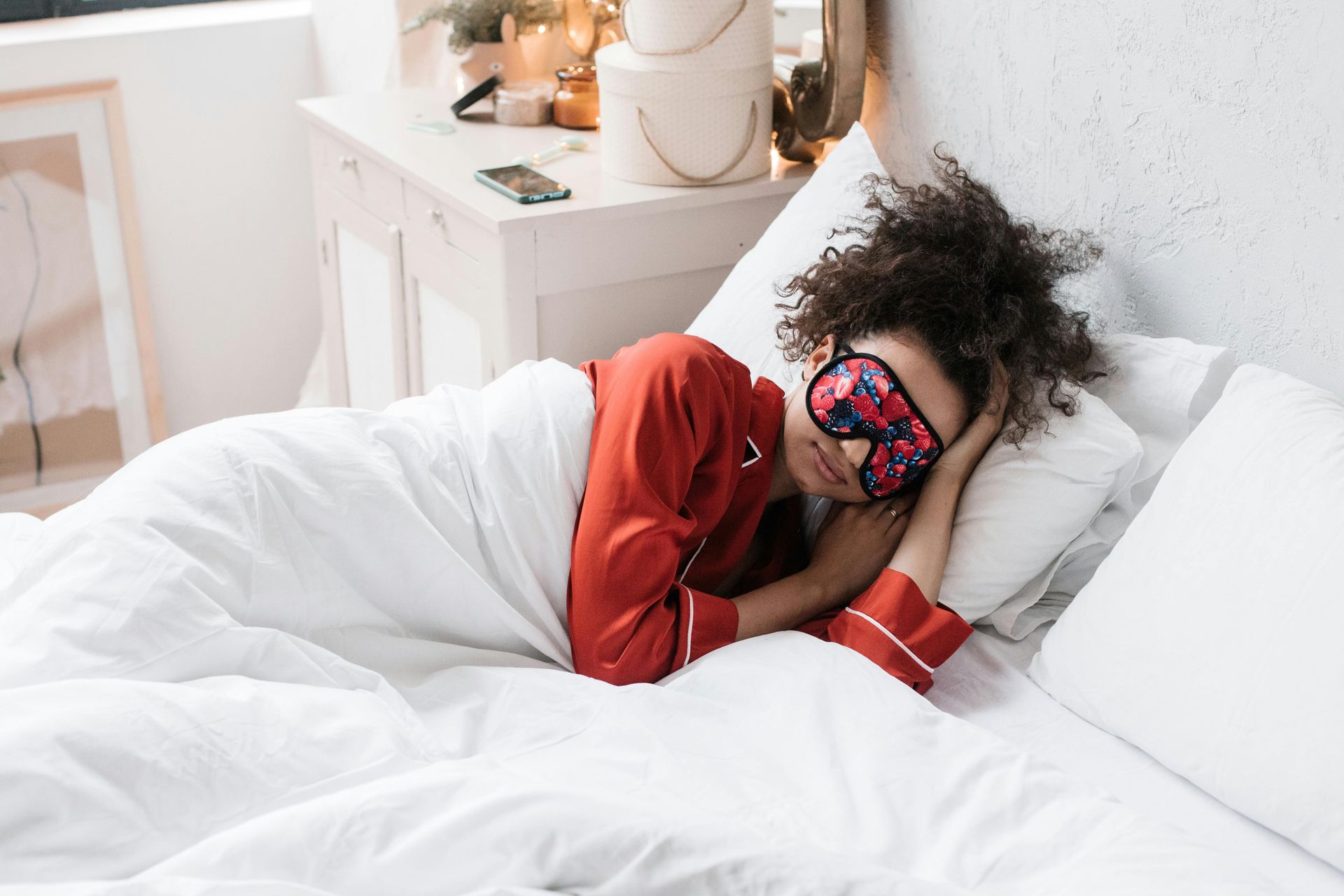 Woman sleeping on white pillow in bed, eyes closed, light skin, brown hair.