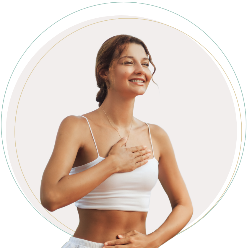 Woman smiling, hands on chest and stomach, white top, light background.