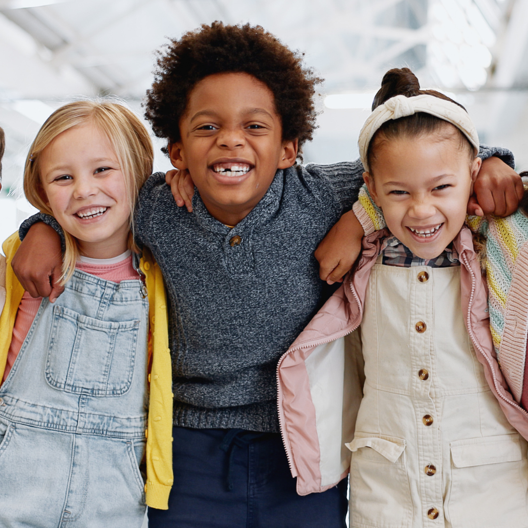 A boy and two girls are posing for a picture together