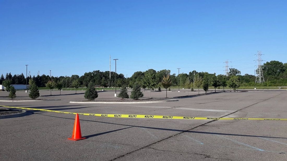 An empty parking lot with a cone in the middle of it.