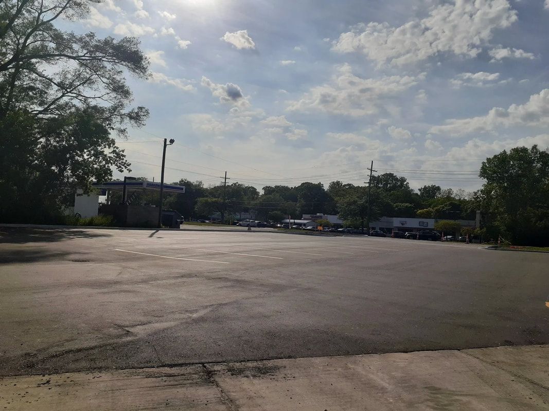 A parking lot with a lot of cars parked in it and trees in the background.