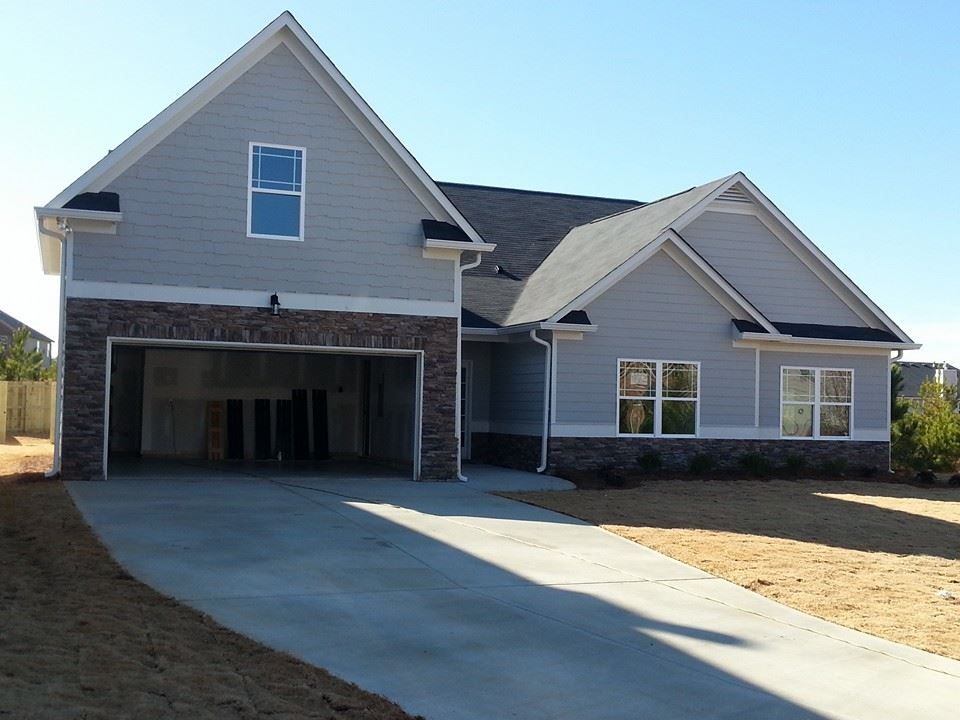 Light blue house with a brick garage and a concrete driveway.