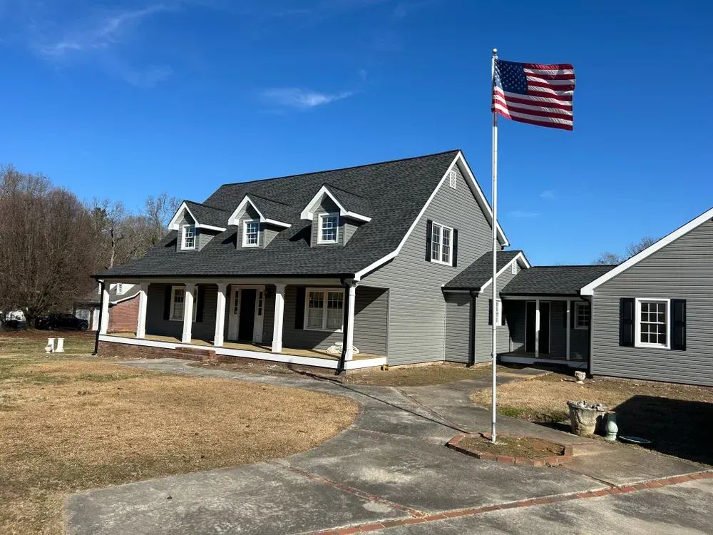 A gray house with an American flag on a sunny day.