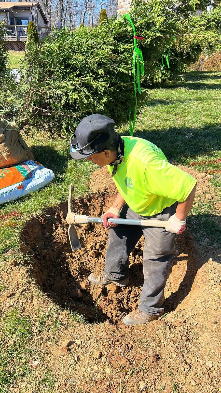 A man is digging a hole in the ground with a shovel.
