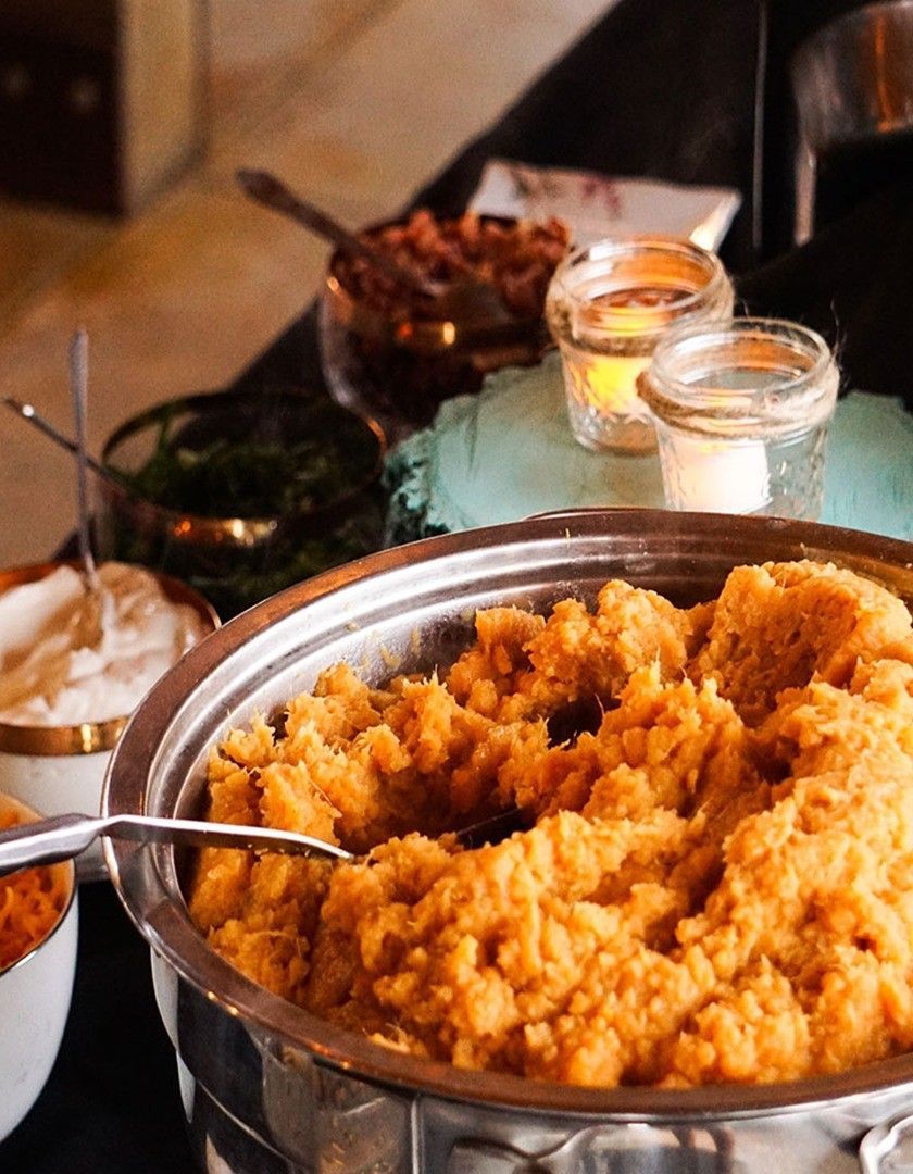 A bowl of mashed potatoes with a spoon in it