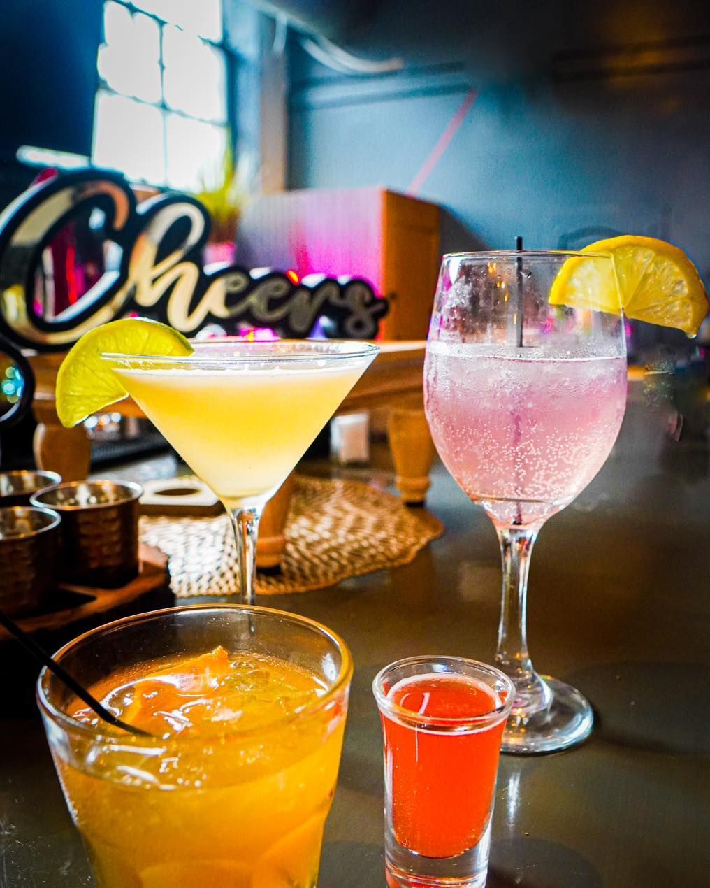 Three different types of drinks are sitting on a bar.