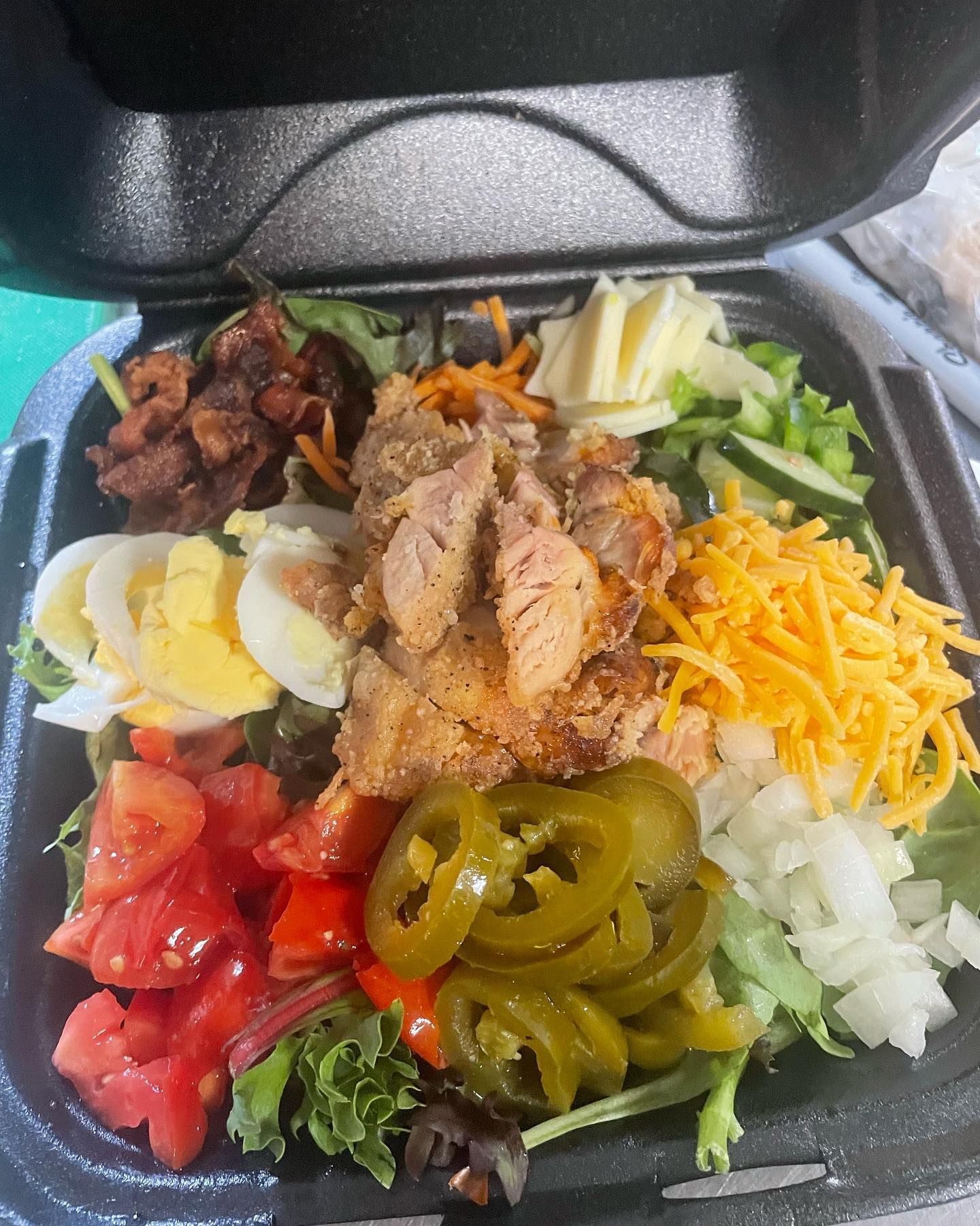 A close up of a salad in a styrofoam container.