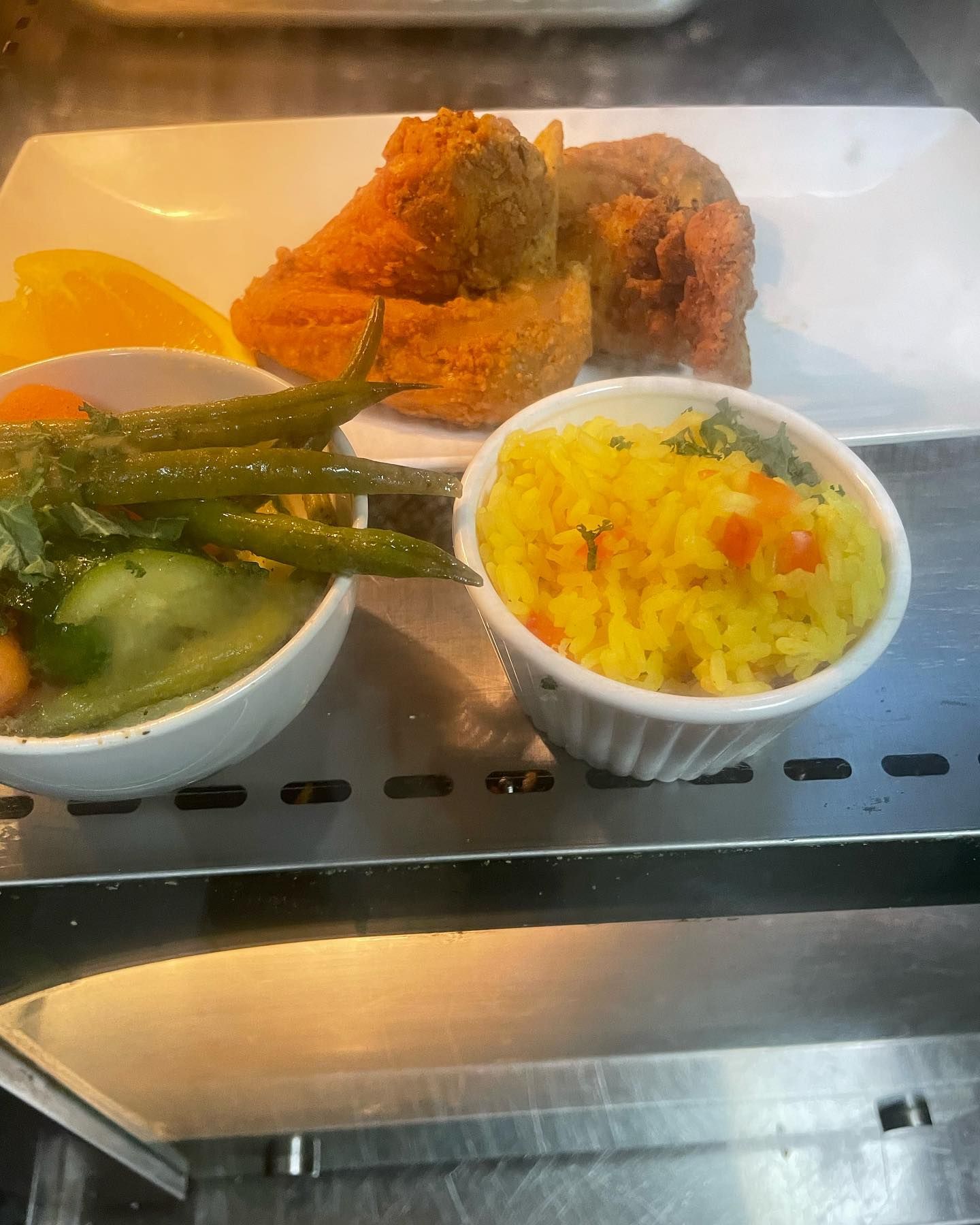 A plate of food with a bowl of rice and vegetables on a shelf.