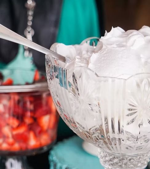 A bowl of whipped cream with a spoon in it