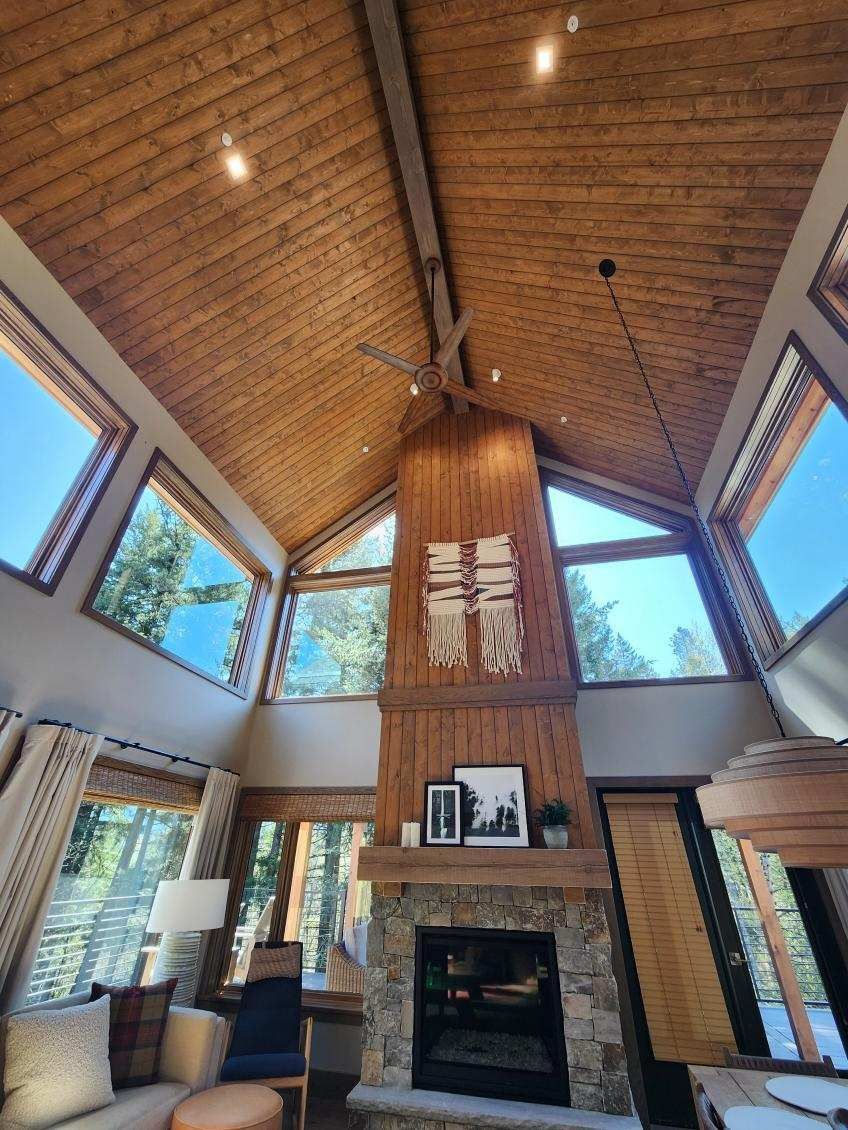 A living room with a fireplace and lots of windows