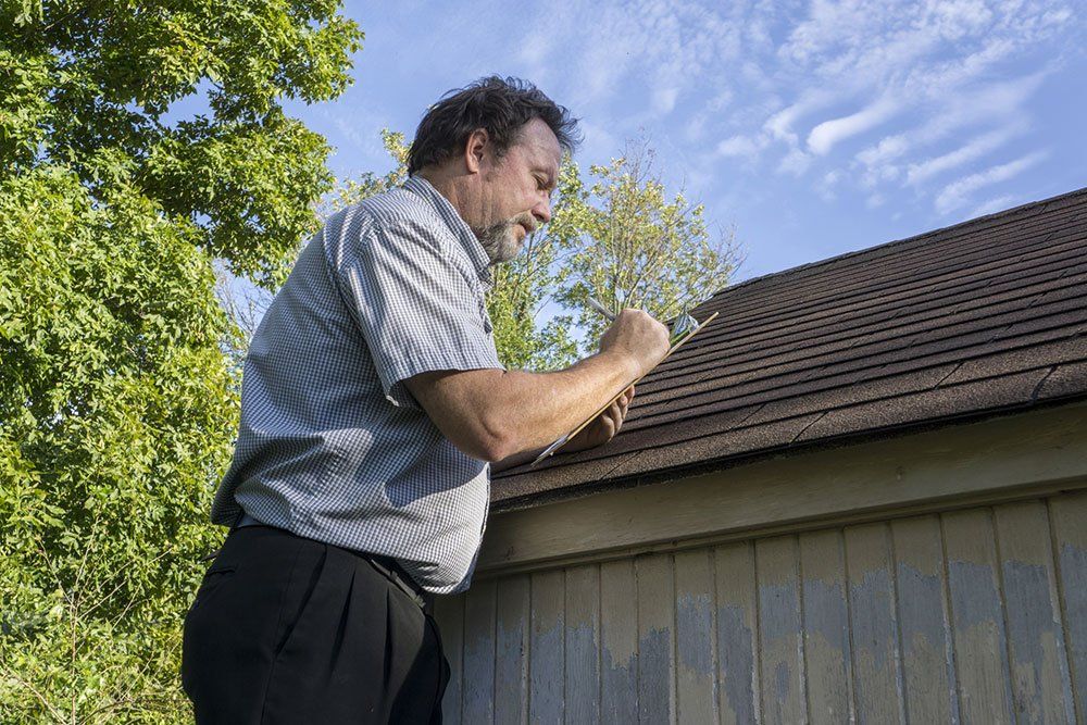 man inspecting roof