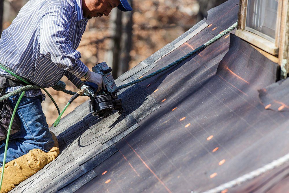 man nailing roof material