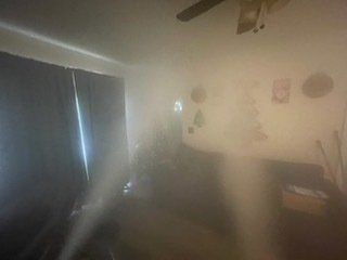 a living room filled with fog and a ceiling fan