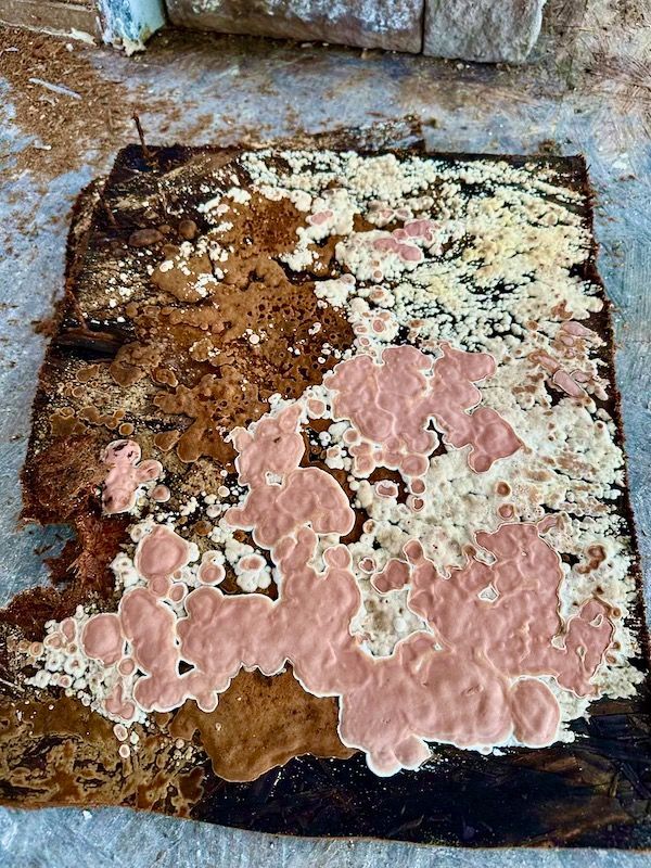 a piece of wood with a lot of pink and white stains on it .