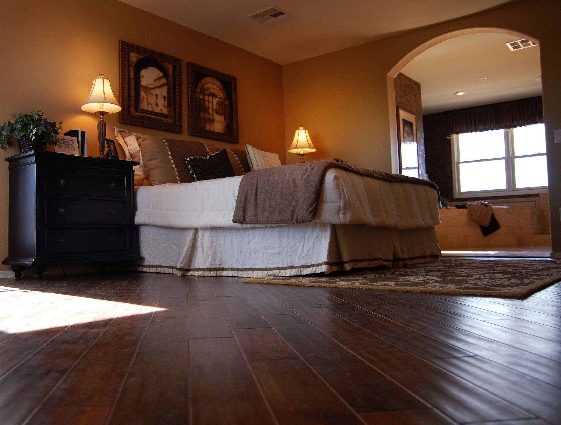 A bedroom with hardwood floors and a large bed