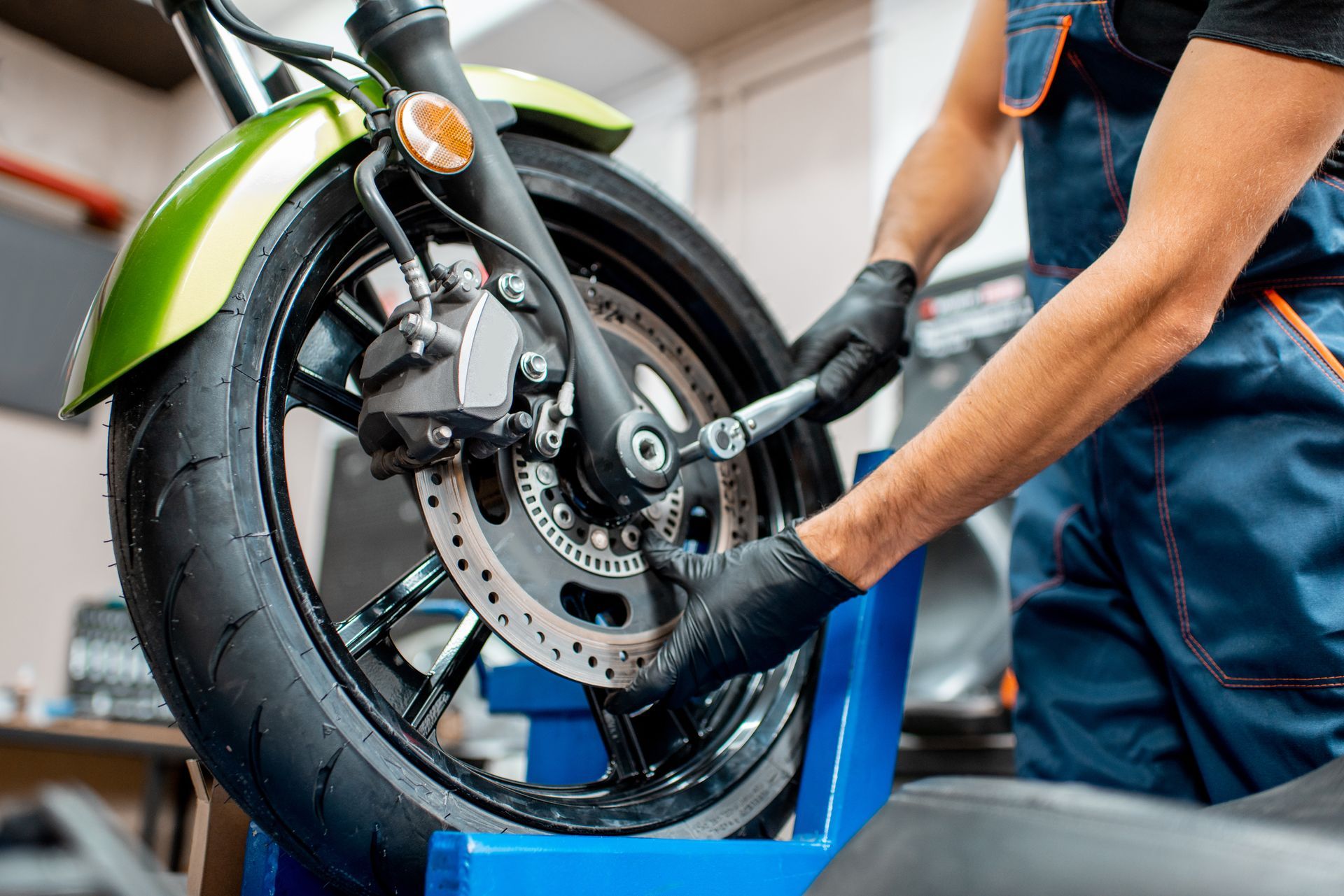 Mechanic inspecting a motorcycle before performing repair services. Mechanic inspecting a motorcycle before performing repair services.