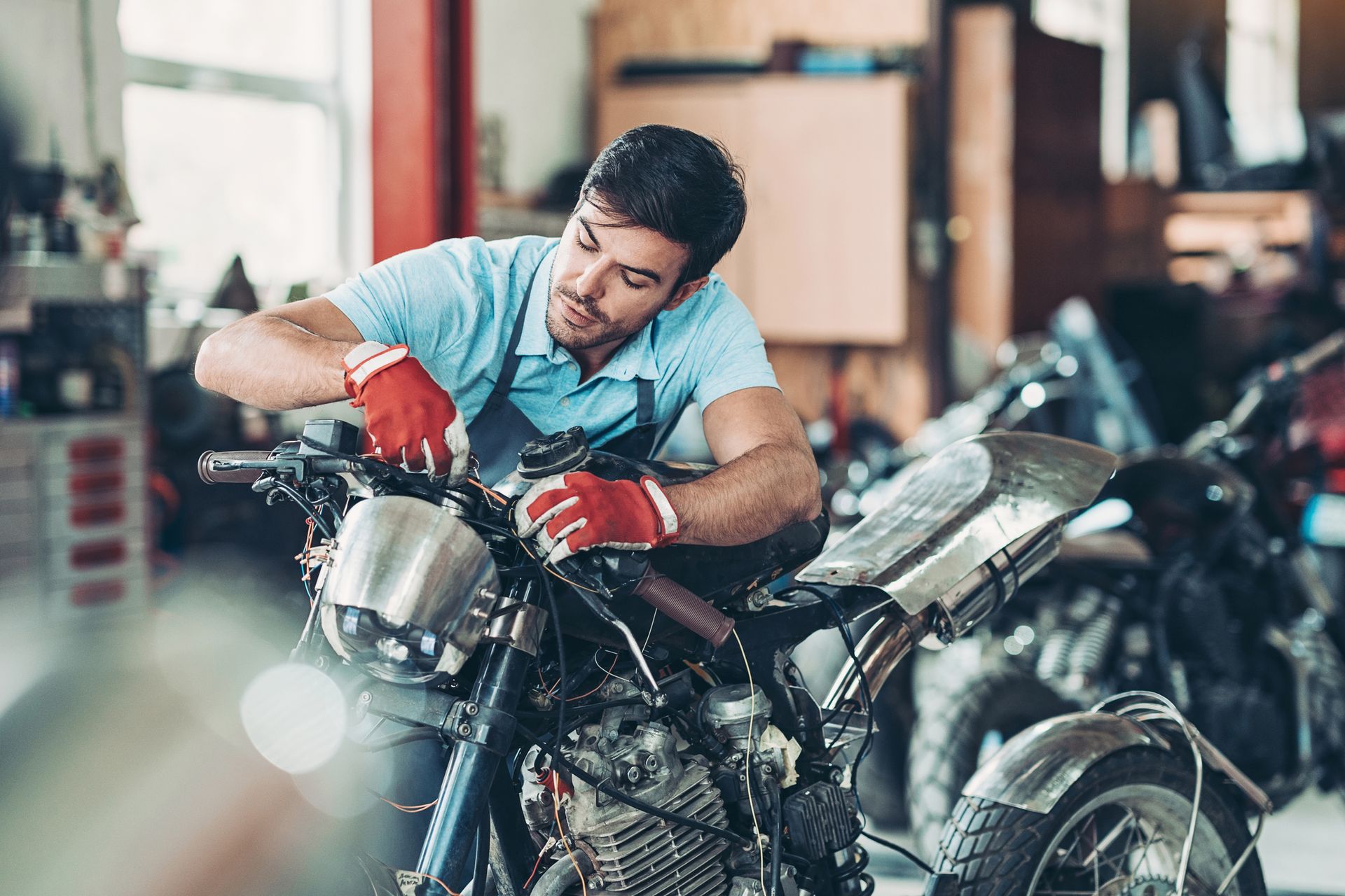 Picture of a mechanic repairing a motorcycle.