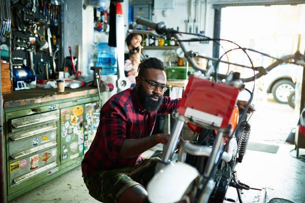 Mechanic inspecting a motorcycle before performing repair services.
