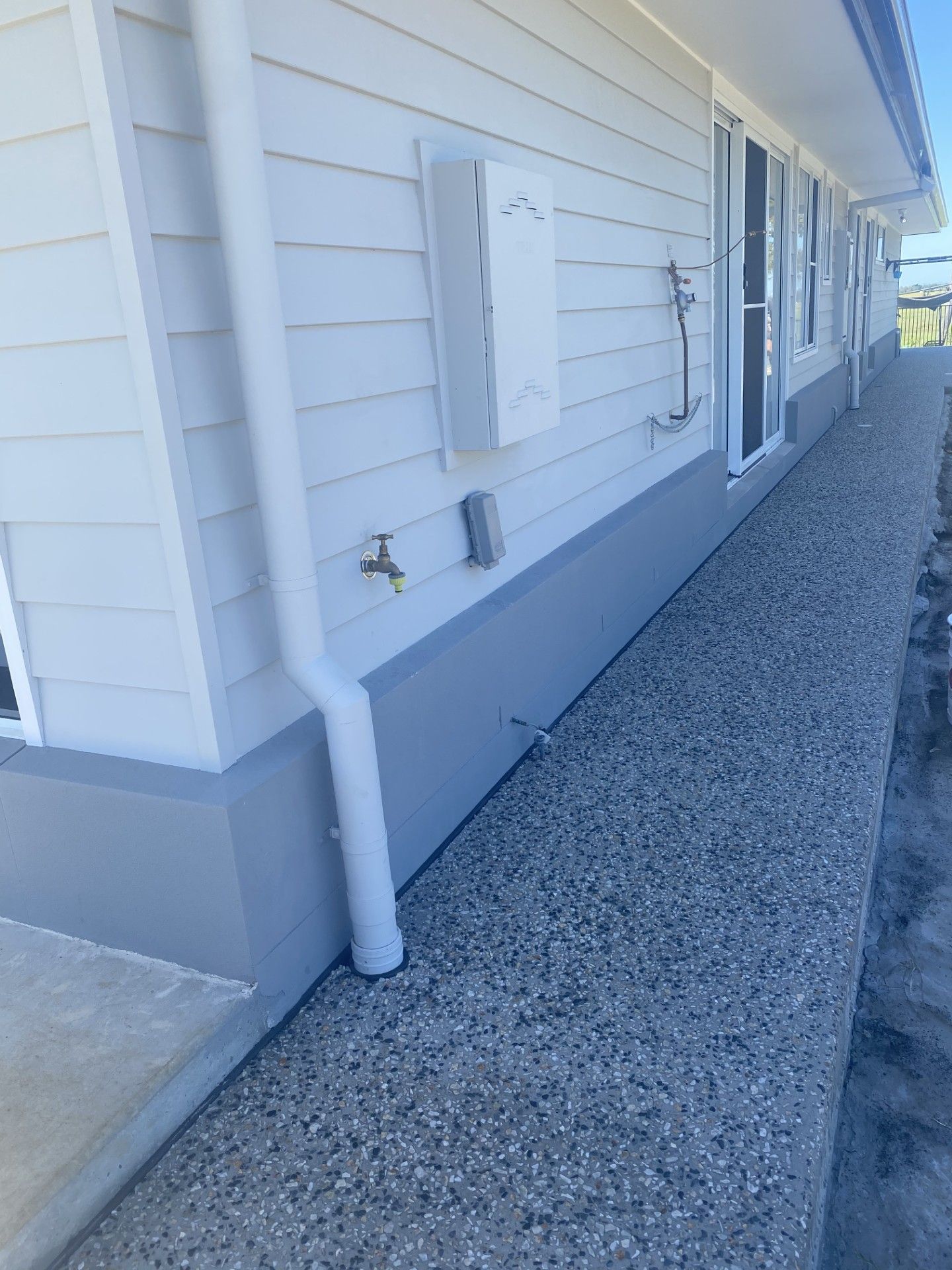 A concrete pathway surrounds a residential house — Wal's Concreting Service in Byron Bay, NSW