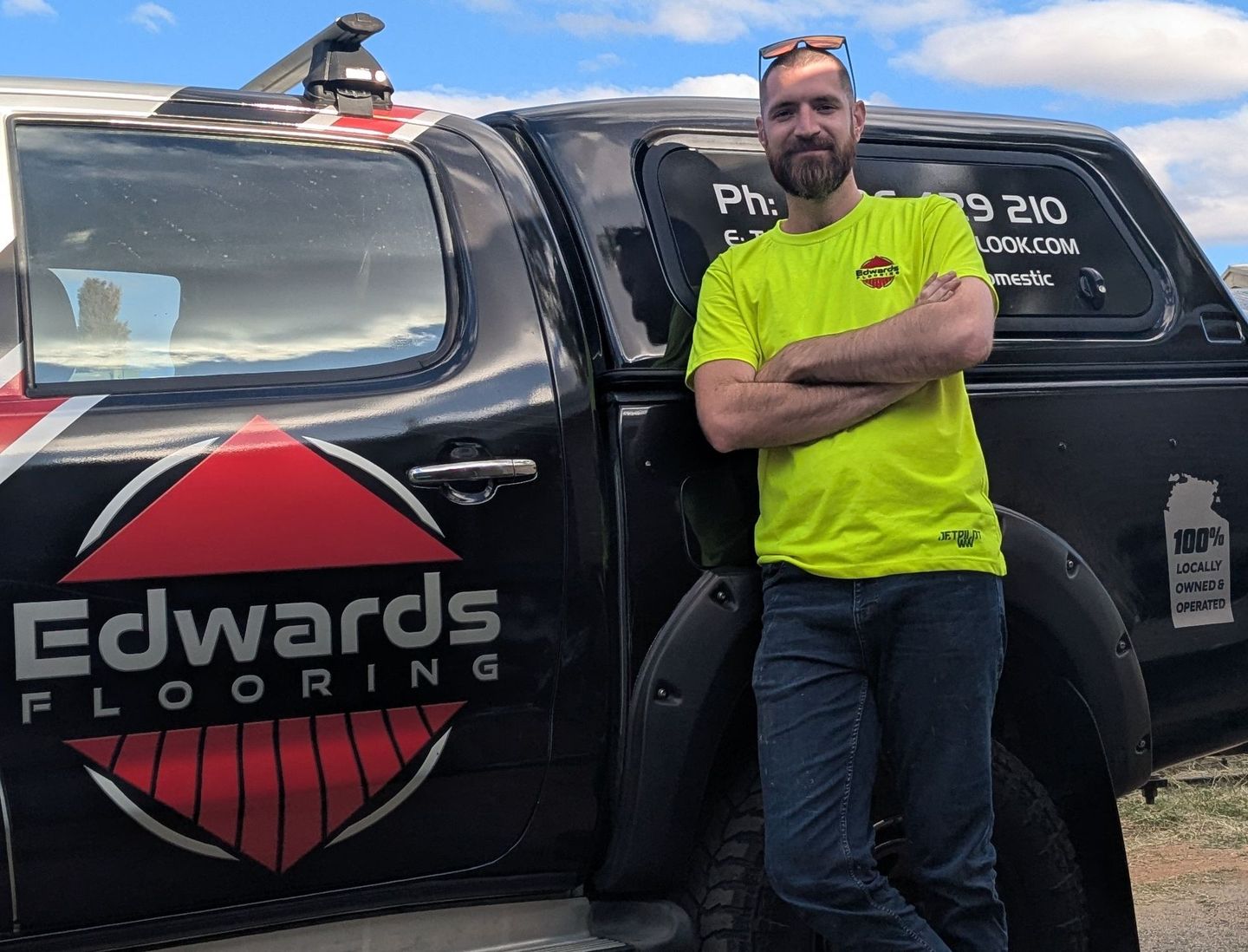 Man in neon shirt, arms crossed, stands by a black truck — Remote Assistant In Braitling, NT