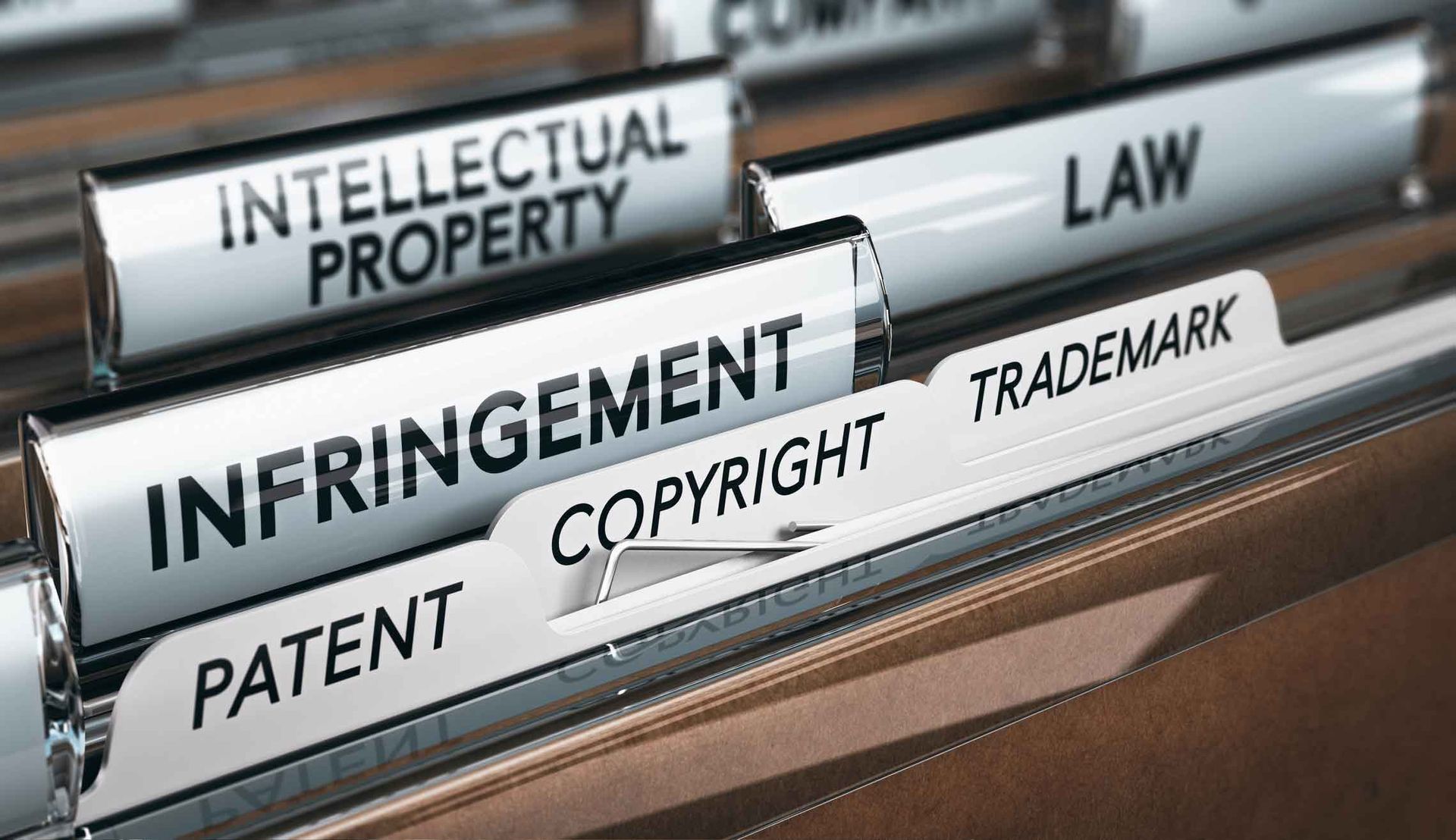 A row of binders with labels that say intellectual property patent copyright and trademark