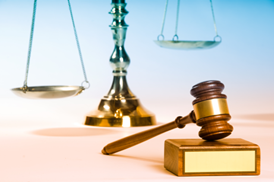 Judge's gavel and scales on a blue background, illustrating the role of solicitors in law.