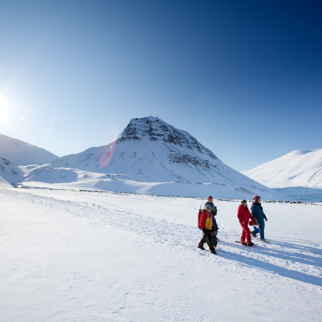 A group of people in a boat in front of a glacier