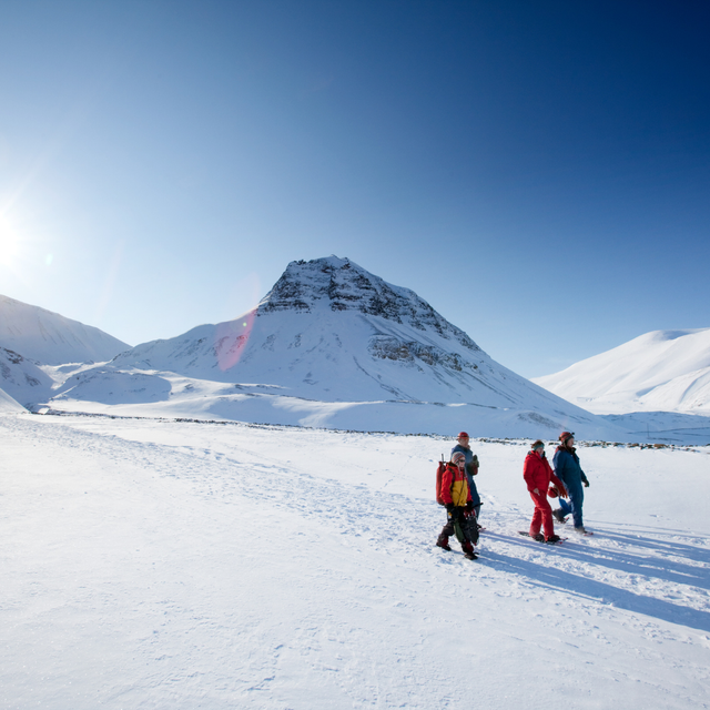 A group of people in a boat in front of a glacier