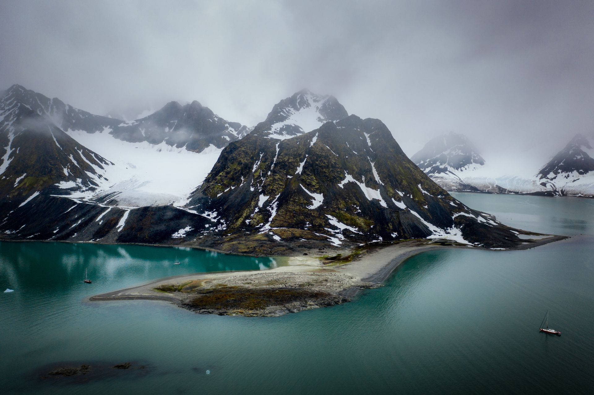 There is a small island in the middle of a lake surrounded by mountains.