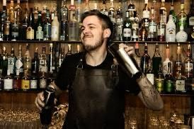A bartender is shaking a drink in a bar.