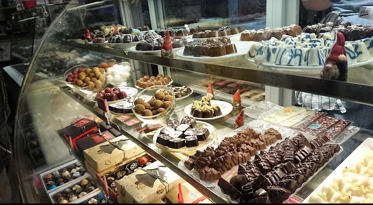 A variety of desserts are displayed in a glass case.