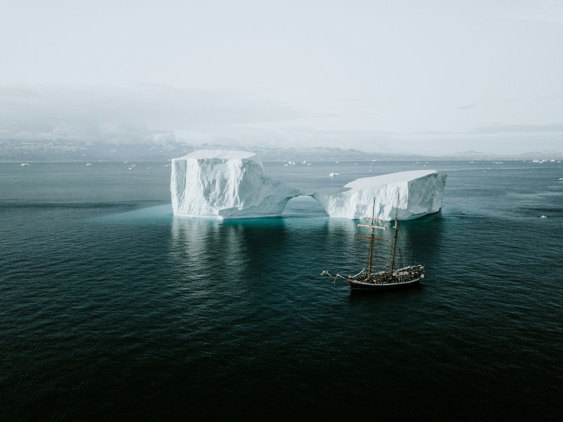 A boat is floating on top of a large iceberg in the ocean.